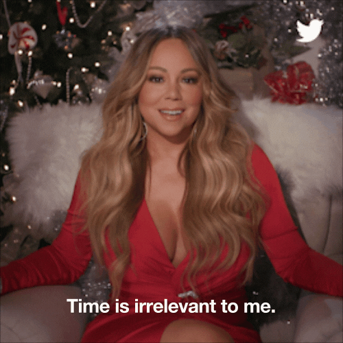 a gif of Mariah Carey saying "Time is irrelevant to me." while sitting in a christmas-y room.